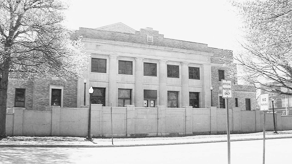 Joplin Memorial Hall closed behind a temporary construction fence.